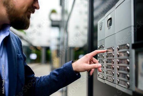 Man pushing the button and talking on the intercom photo