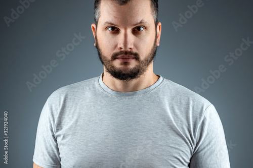 Studio portrait Handsome young bearded man on a gray background.