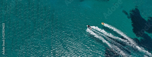 Aerial drone ultra wide photo of water sports in Super Paradise beach in island of Mykonos, Cyclades, Greece