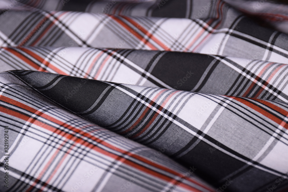 Tartan plaid patterned material laid out on a table Tartan plaid patterned material laid out on a table