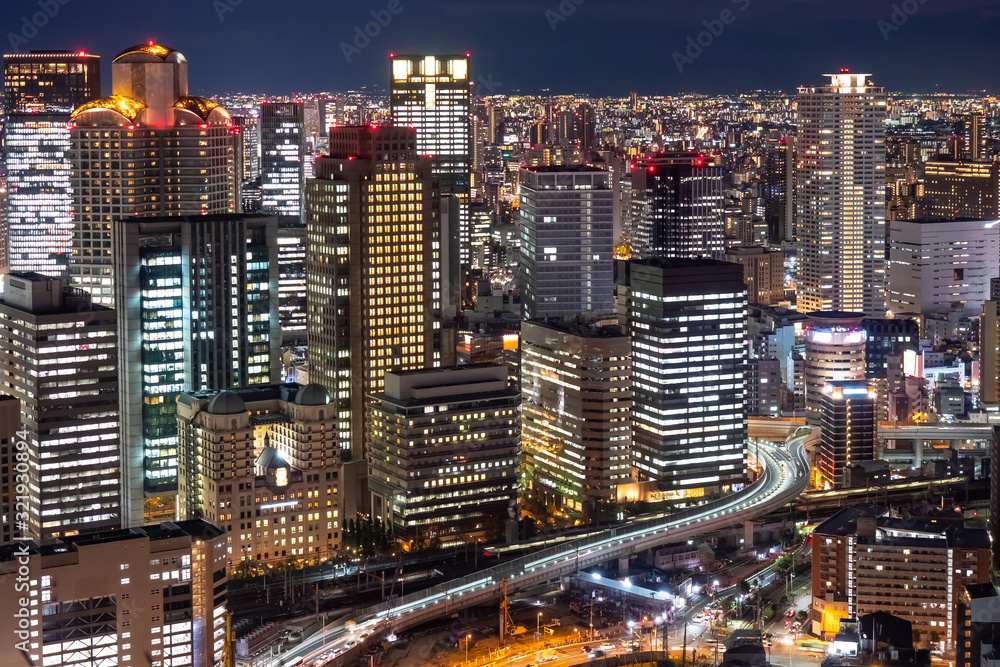 Japan. Osaka. Evening panorama of the big city. View of Osaka business center from a height. Buildings with glowing Windows and roads. Cities of Japan. Modern urban architecture.