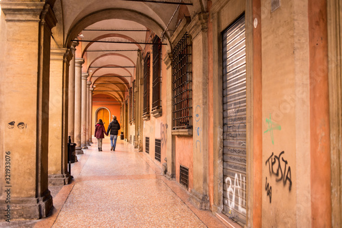 Foto Couple walking in Bologna porticoes covered footpath in the  historical medieval centre of Bologna city