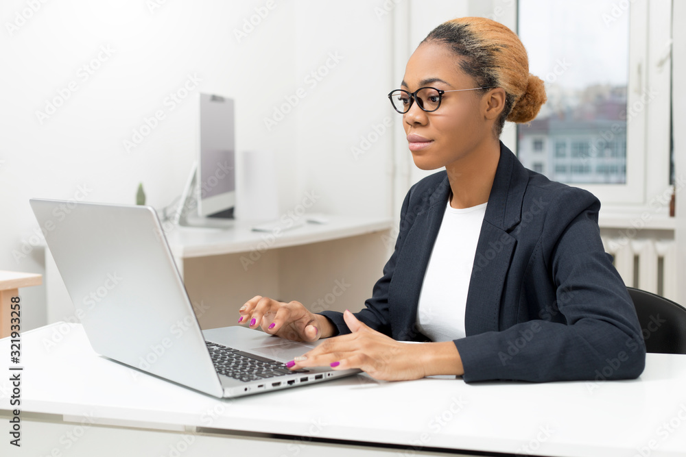 Portrait of a business African American woman working at a computer at her workplace. Portrait of a business African American woman working at a computer at her workplace.