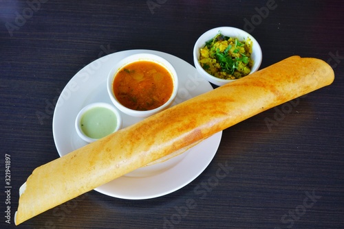 A plate with masala dosa bread stuffed with potatoes at an Indian restaurant photo