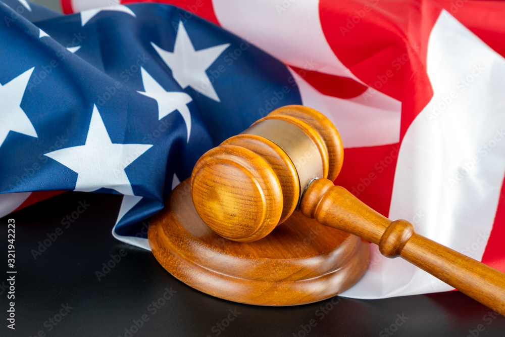Judge gavel and striking block on black background and the american national flag. Copy space for text. To illustrate crime justice and election in the us.