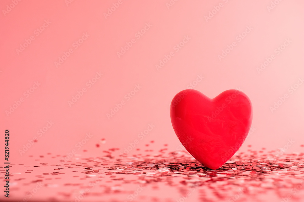 Valentine's Day background . red gloss heart with confetti on pink pastel background with copy space. wedding wallpaper.
