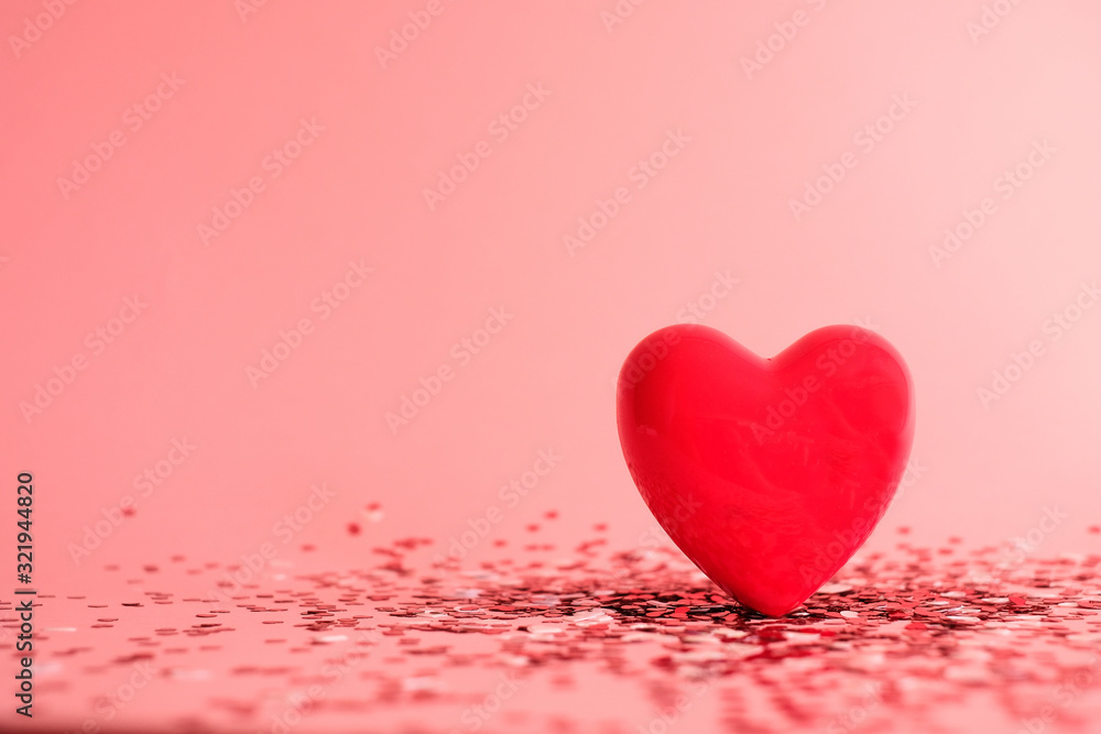 Fototapeta premium Valentine's Day background . red gloss heart with confetti on pink pastel background with copy space. wedding wallpaper.