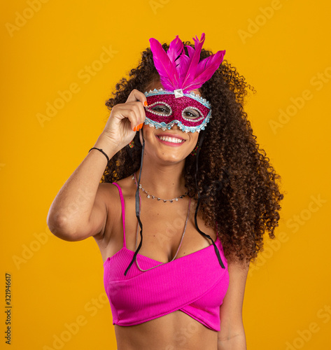 Beautiful woman dressed for carnival night. Smiling woman ready to enjoy the carnival with a colorful mask.
