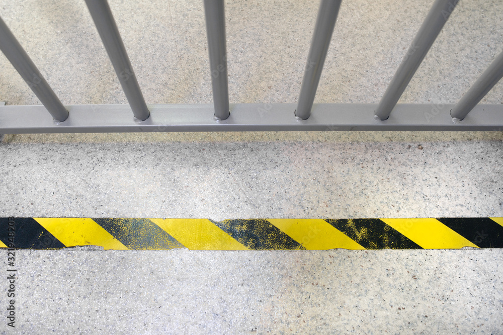 Fototapeta premium Grey cells in the bank with the yellow do not cross tape on the floor.