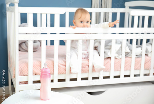 Baby Peeking from Crib with...