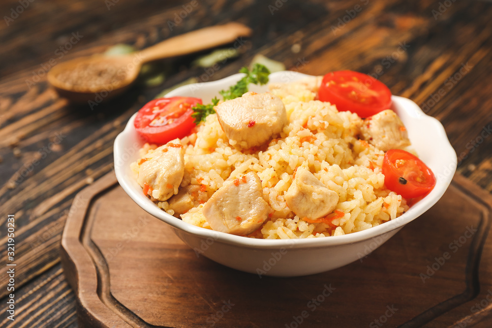 Bowl with tasty rice and chicken on table Bowl with tasty rice and chicken on table