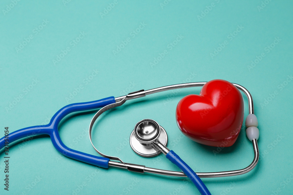 Stethoscope and heart on color background. Cardiology concept Stethoscope and heart on color background. Cardiology concept