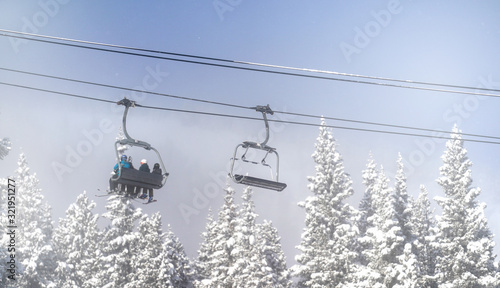 Chair lift above snowy trees at ski resort