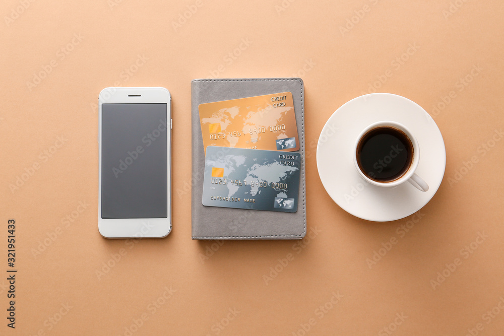 Credit cards with mobile phone and cup of coffee on color background. Concept of online banking Credit cards with mobile phone and cup of coffee on color background. Concept of online banking