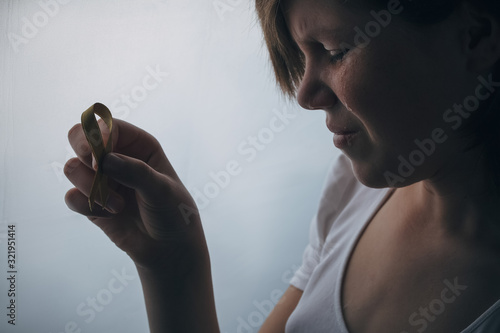 girl with golden ribbon in hand fighting cancer
