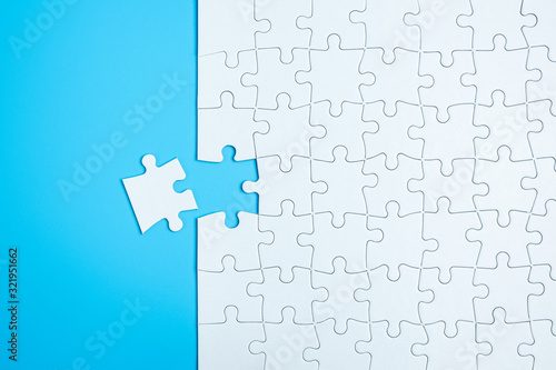 Blue background made from white jigsaw puzzle pieces and place for your content