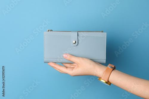 Female hand with wallet on color background