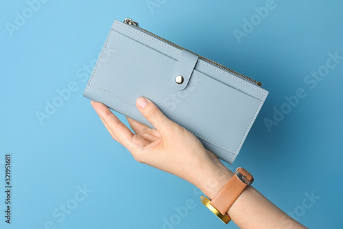 Female hand with wallet on color background