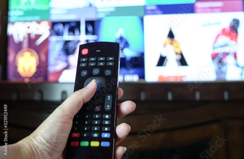 Female hand holding a smart tv remote control photo