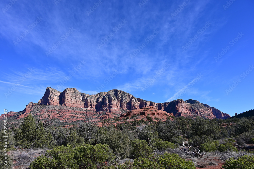 Red rock formations near Sedona, Arizona under wispy high altitude clouds on a clear winter morning.