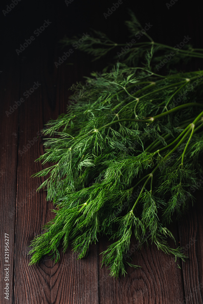 Dill sheaf on a dark wooden rustic board, close up Dill sheaf on a dark wooden rustic board, close up