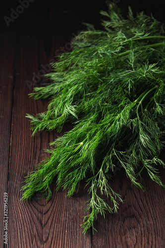 Dill sheaf on a dark wooden rustic board, close up