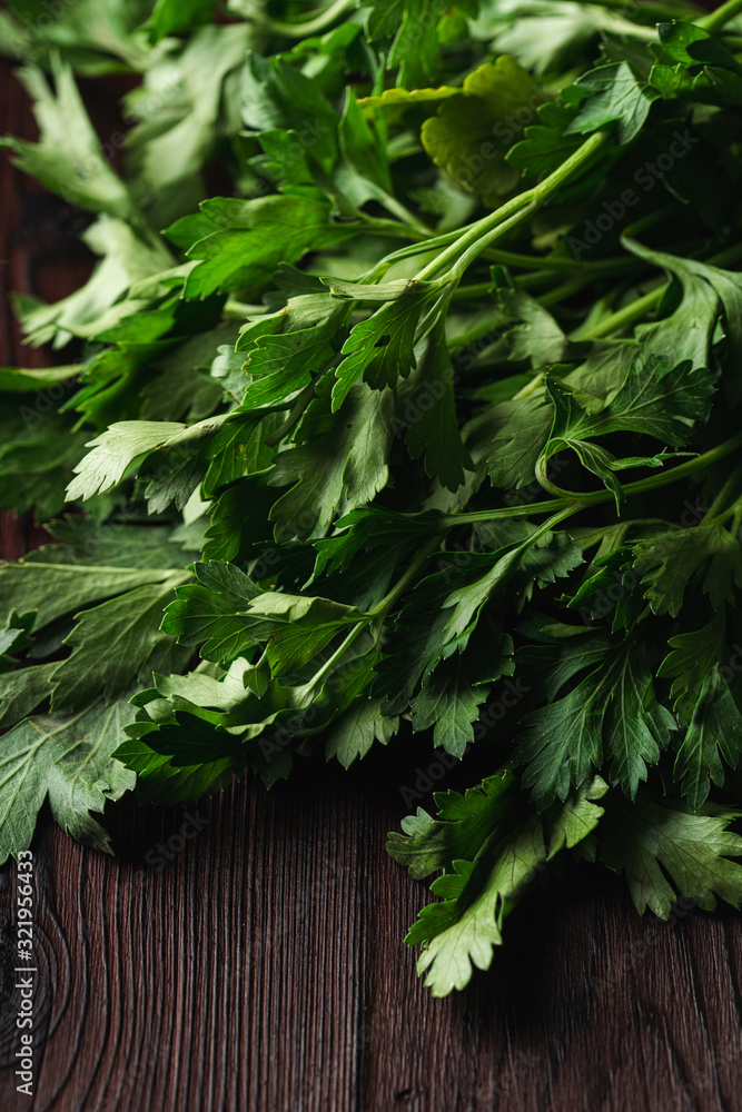 Bundle of fresh raw parsley on dark wooden table close up Bundle of fresh raw parsley on dark wooden table close up