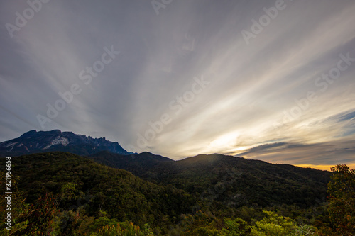 Sunrise at the Mount Kinabalu, Borneo, Sabah, Malaysia. The sun comes up behind the highest mountain in South east Asia, the mount kinabalu. Near the city of Kota Kinabalu. Colorful clouds at the sky
