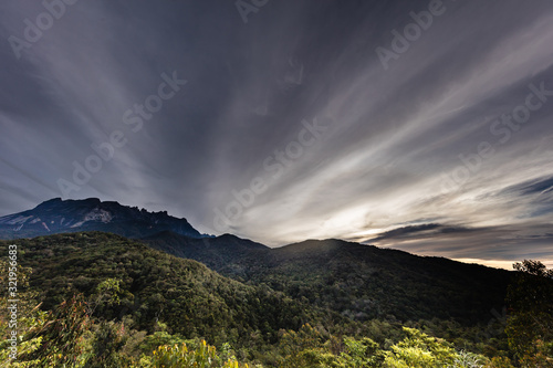 Sunrise at the Mount Kinabalu, Borneo, Sabah, Malaysia. The sun comes up behind the highest mountain in South east Asia, the mount kinabalu. Near the city of Kota Kinabalu. Colorful clouds at the sky