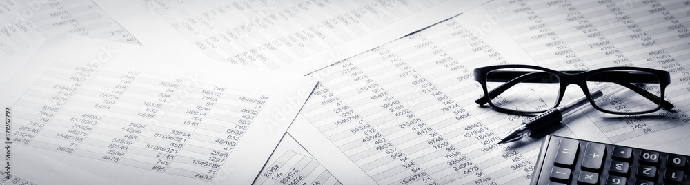 Business banner, calculator, pen and eyeglasses on report Business banner, calculator, pen and eyeglasses on report