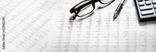 Business banner  calculator  pen and eyeglasses on report