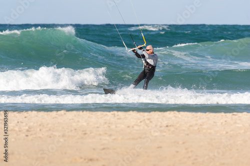 A man over 60 years old rides a kiteboarding