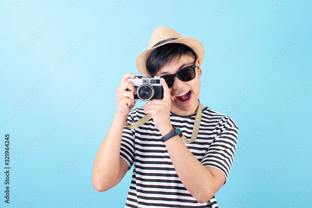 Asian tourists taking pictures with film cameras on a blue background. Isolated background. Asian tourists taking pictures with film cameras on a blue background. Isolated background.