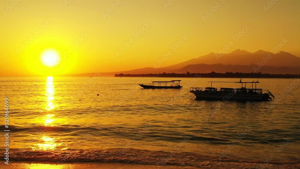 Beautiful yellow sunset reflecting off the surface of the rippling water at a beach island resort Beautiful yellow sunset reflecting off the surface of the rippling water at a beach island resort
