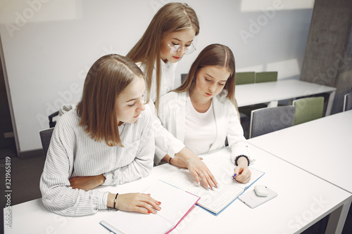 Students in a park. Girls lying on a grass. Friends with a notebooks. photo