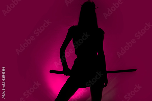 Silhouette ow sexy slim woman with samurai sword , purple background
