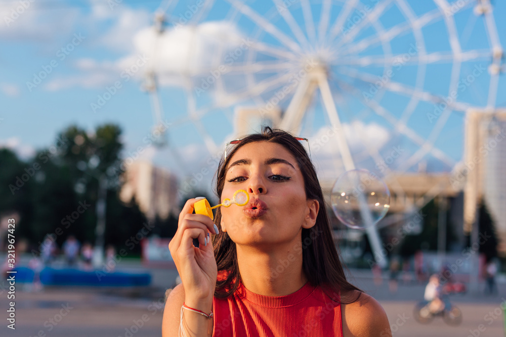 Beautiful young woman blowing soap bubbles outdoors - obrazy, fototapety, plakaty 