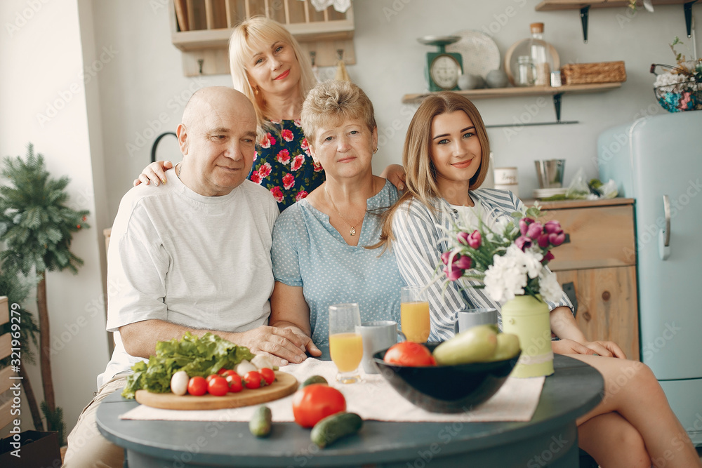 Family in a kitchen. Grandparents with grandchildren. People with vegetables Family in a kitchen. Grandparents with grandchildren. People with vegetables