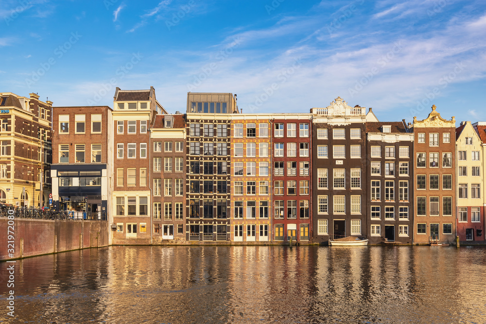Amsterdam Netherlands, city skyline at canal waterfront and bridge with traditional house in Damrak