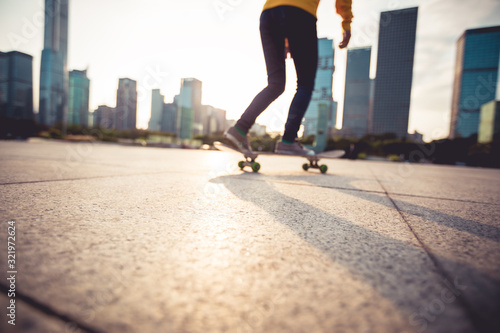 Fototapeta Naklejka Na Ścianę i Meble -  Skateboarder skateboarding at sunset city