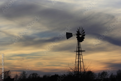 Kansas Windmill at Sunset with a colorful sky out in the country north of Hutchinson Kansas USA.