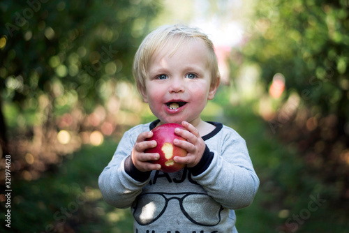 child eating an apple in park