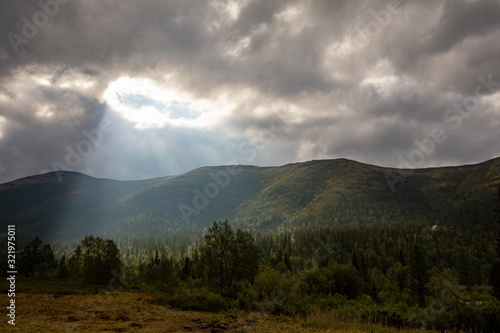 Mountain landscape. A ray of the sun breaks through the clouds