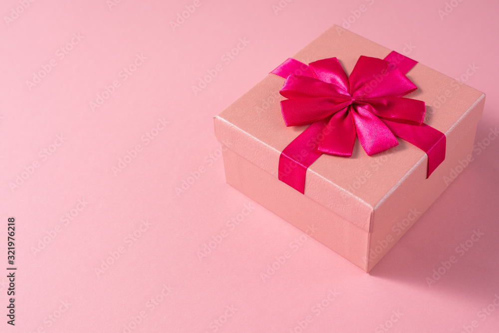 Valentine's Day celebration concept. A nice gift from a loved one. Box with a bow on a delicate pink background. Copy space. Flat lay. Close-up. Valentine's Day celebration concept. A nice gift from a loved one. Box with a bow on a delicate pink background. Copy space. Flat lay. Close-up.