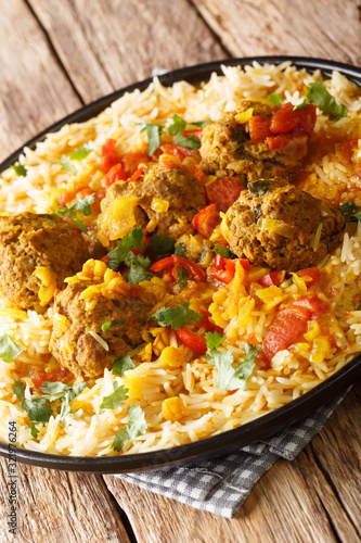 Kofta Chalao. Sauteed meatballs simmered in a blend of Afghan spices, garlic and onions, served with Basmati rice close-up in a plate. Vertical photo