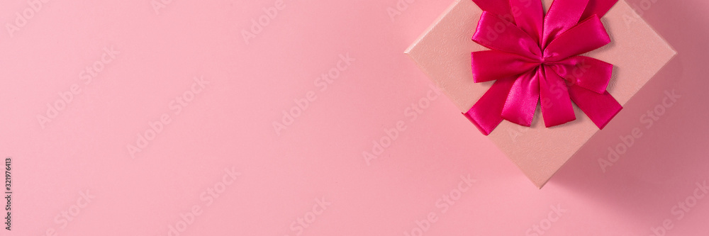 Valentine's Day celebration concept. A nice gift from a loved one. Box with a bow on a delicate pink background. Copy space. Flat lay. Banner. Valentine's Day celebration concept. A nice gift from a loved one. Box with a bow on a delicate pink background. Copy space. Flat lay. Banner.