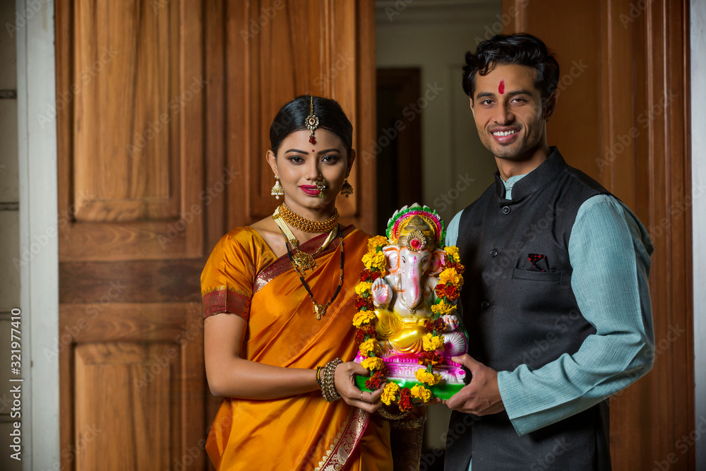 Maharashtrian couple in traditional dress celebrating ganapati