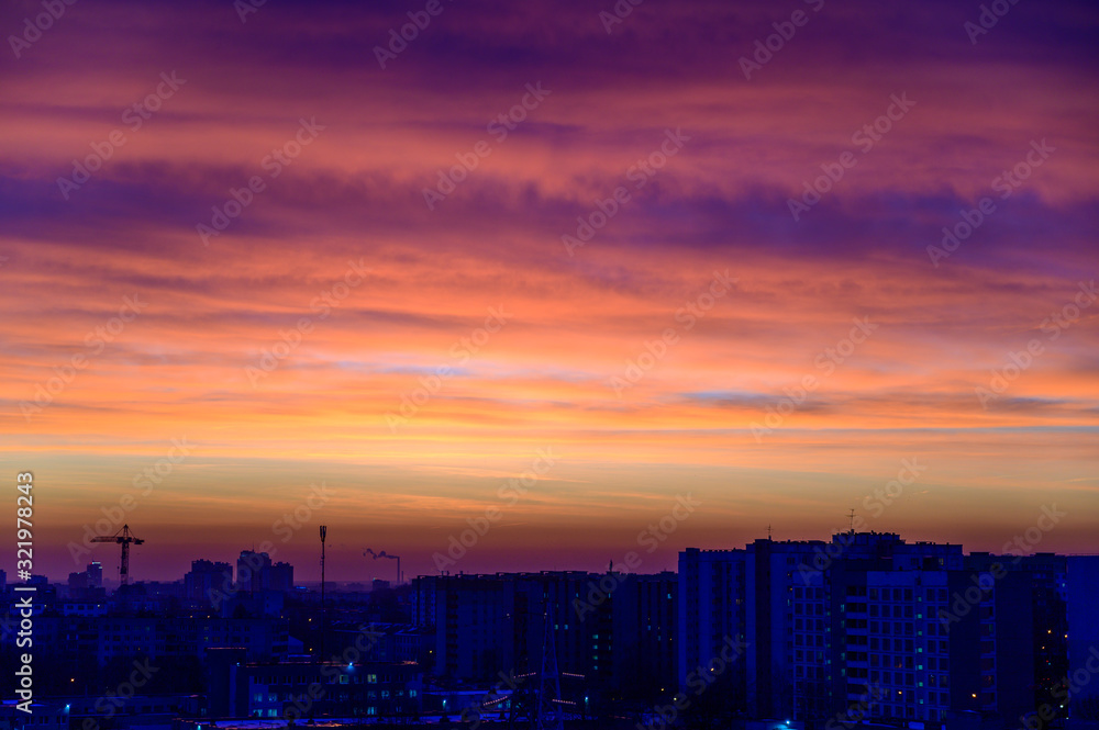 Photo of a dark sky over the city in the early autumn morning with colorful clouds