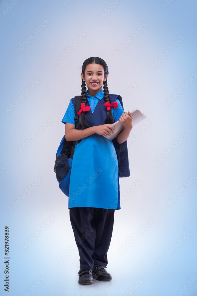 Portrait of school girl holding book and bag Stock Photo | Adobe Stock