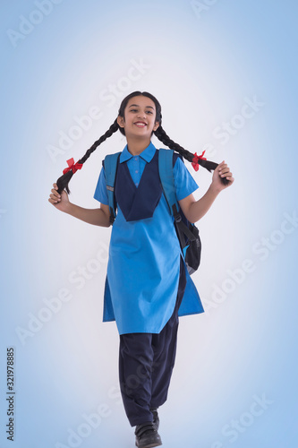 Portrait of rural school girl in uniform holding her hair © IndiaPix